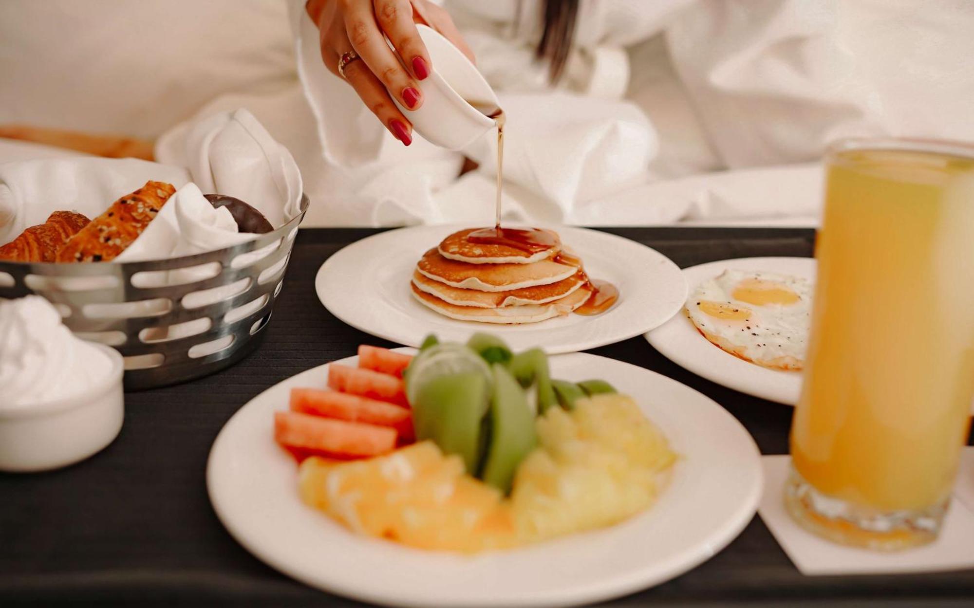 Radisson Blu Hotel Амритсар Экстерьер фото A woman pouring maple syrup on a stack of pancakes